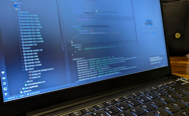 Android Studio open on a laptop with the FamilyDose project files and resources